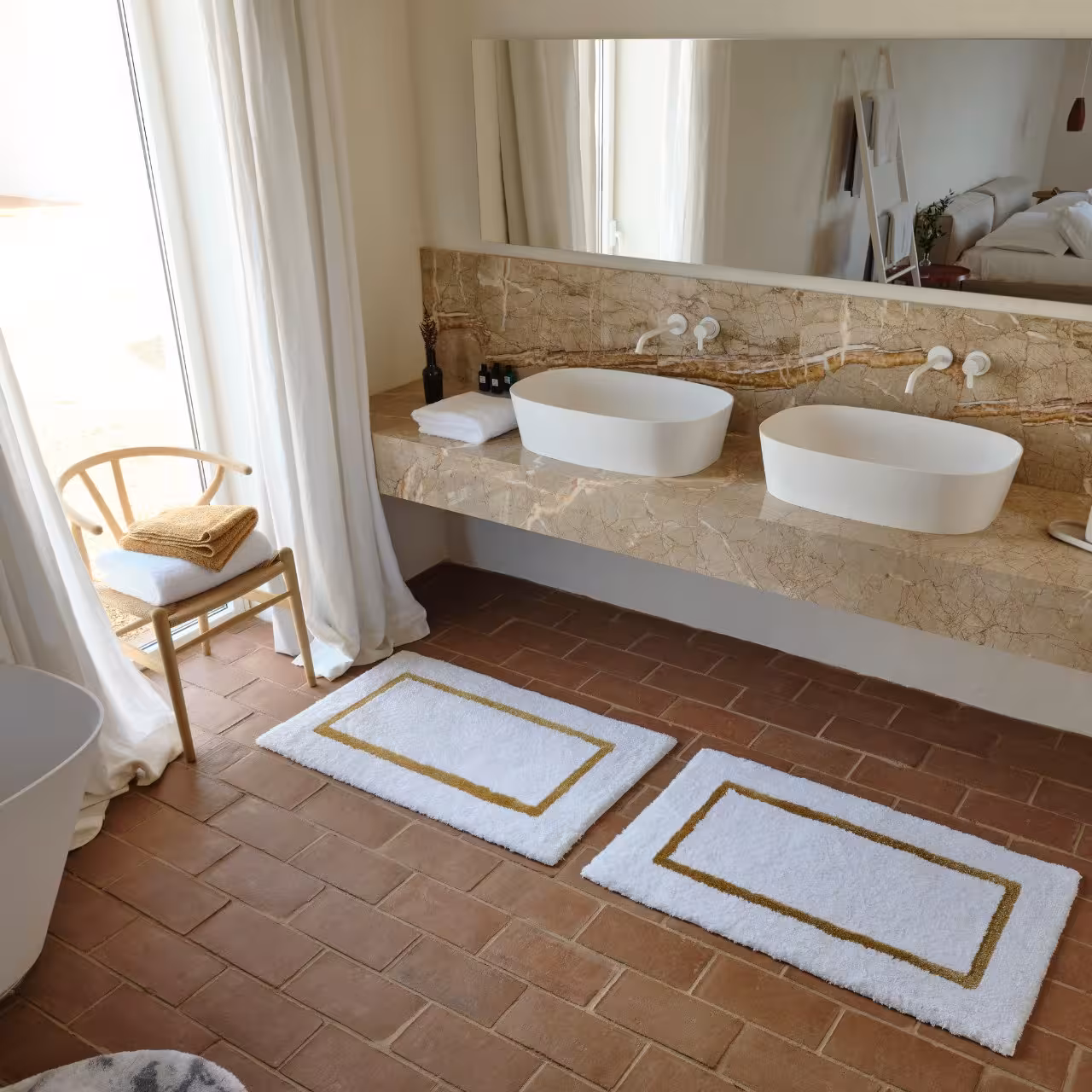 Badezimmer mit Terracottaboden und zwei Waschbecken 