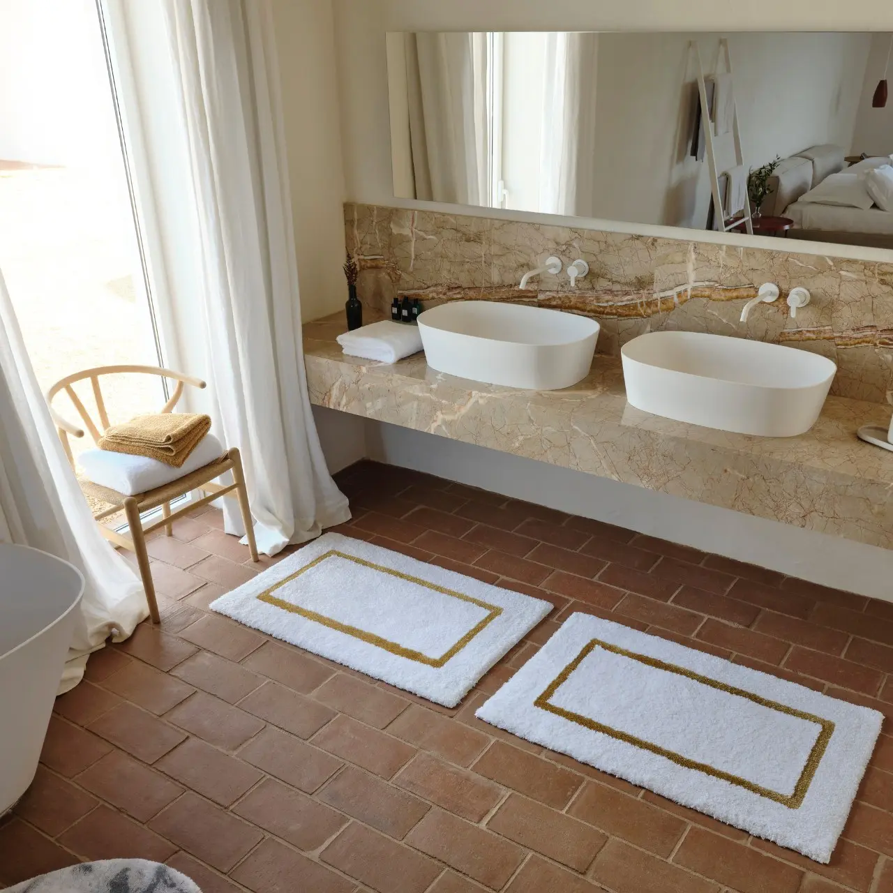 Badezimmer mit Terracottaboden und zwei Waschbecken 