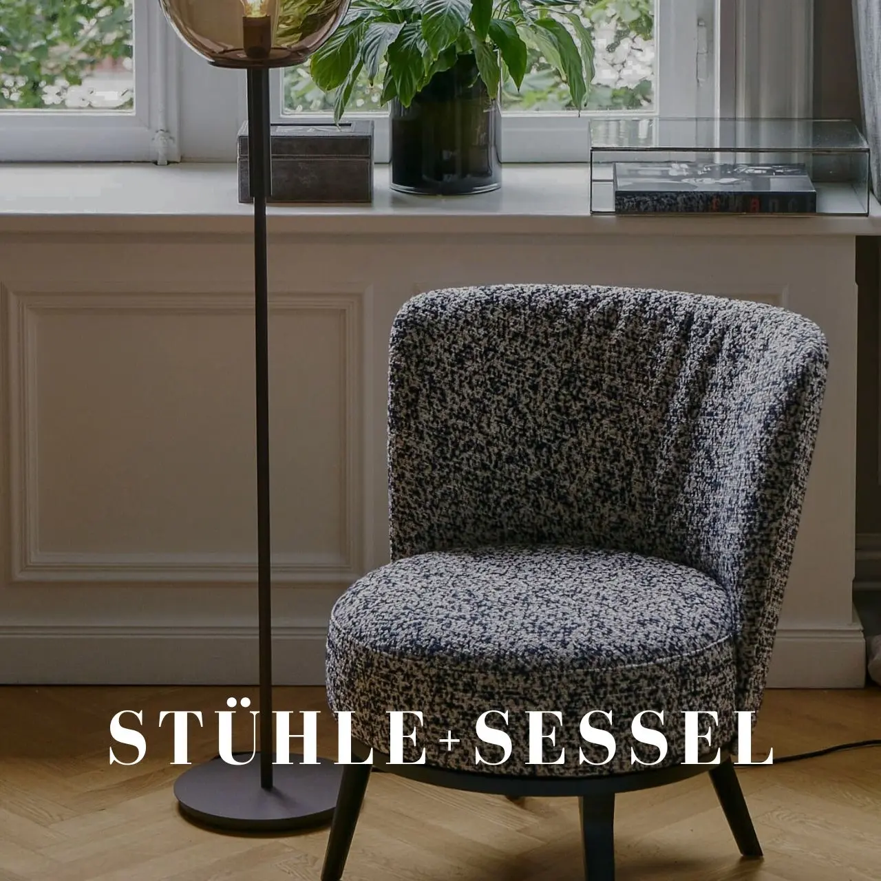 Grauer Cocktailsessel neben Stehlampe