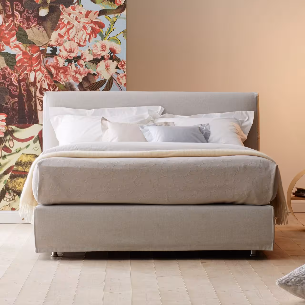 Doppelbett Chill mit beigem Stoff in Schlafzimmer vor floraler Tapete