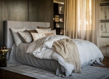 Bett mit vielen Kissen und Fischbacher Bettwäsche in Beige-Tönen