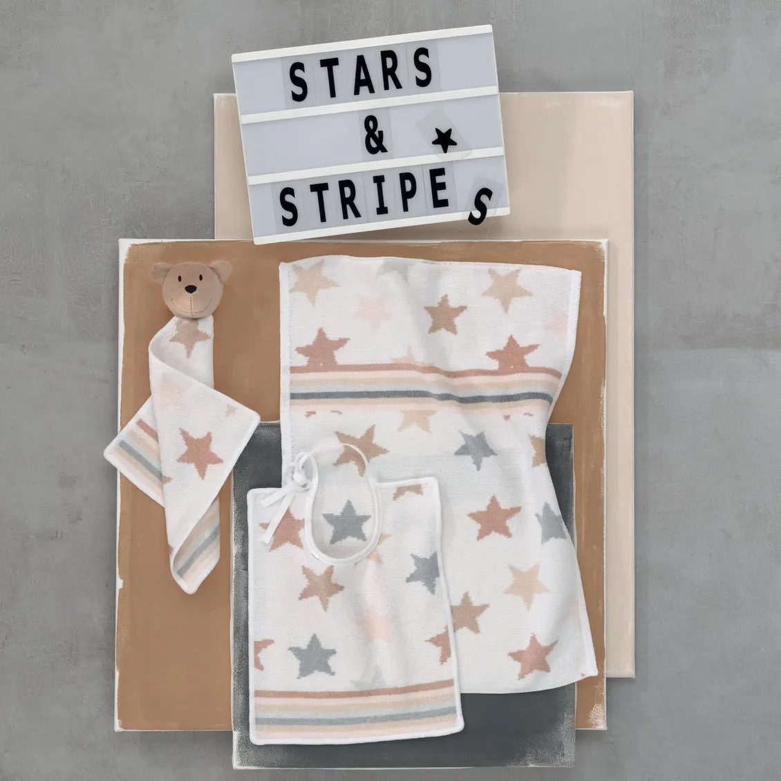 Chenilleserie Stars and Stripes creme mit silbernen und goldenen Sternen dekoriert