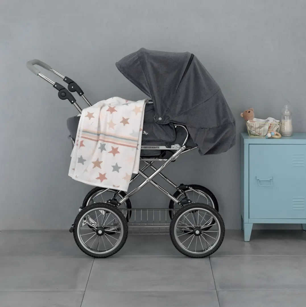 Chenilleserie Stars and Stripes creme mit silbernen und goldenen Sternen dekoriert an Kinderwagen