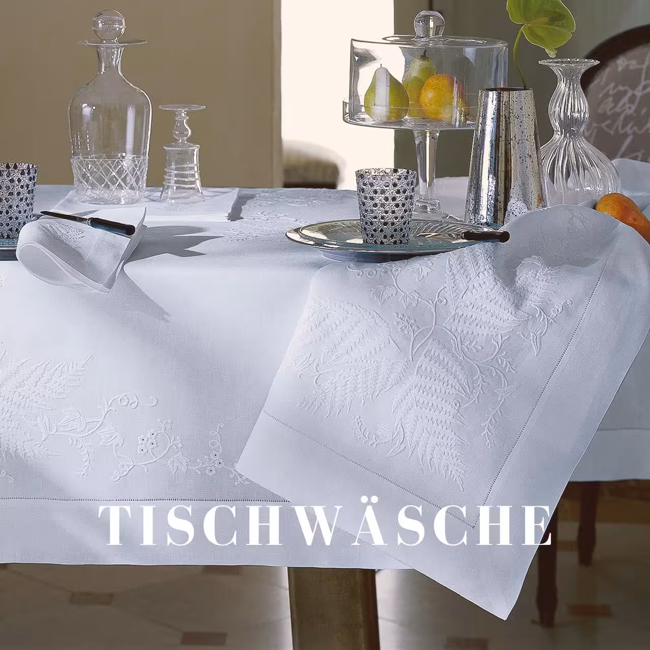 Tisch mit Gläsern und weißer Tischdecke