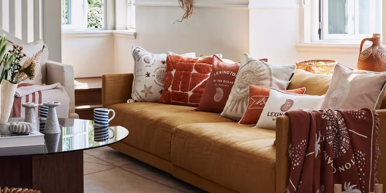 Senfgelbes Sofa mit Lexington Kissen und Decke in warmen Rot- und Beige-Tönen