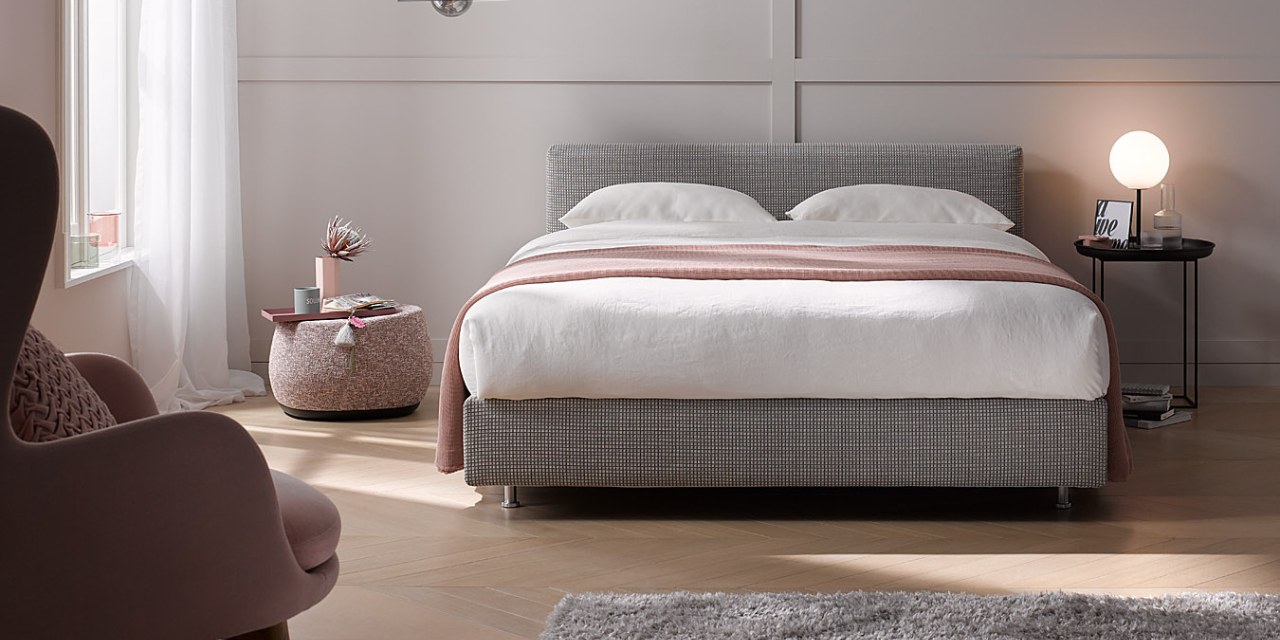 Marke Schramm: Betten und Matratzen Graues Schramm Boxspringbett in hellem Zimmer mit Altrosa- und Beige-Tönen