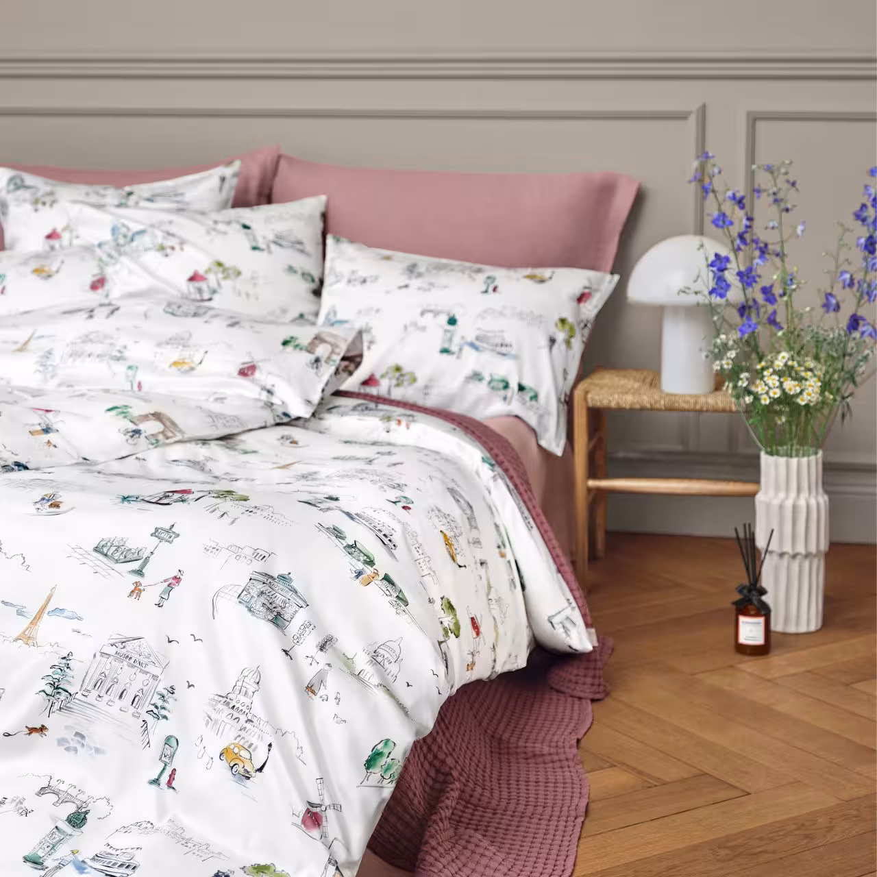 Weiß-bunte Bettwäsche auf Bett mit Nachttisch