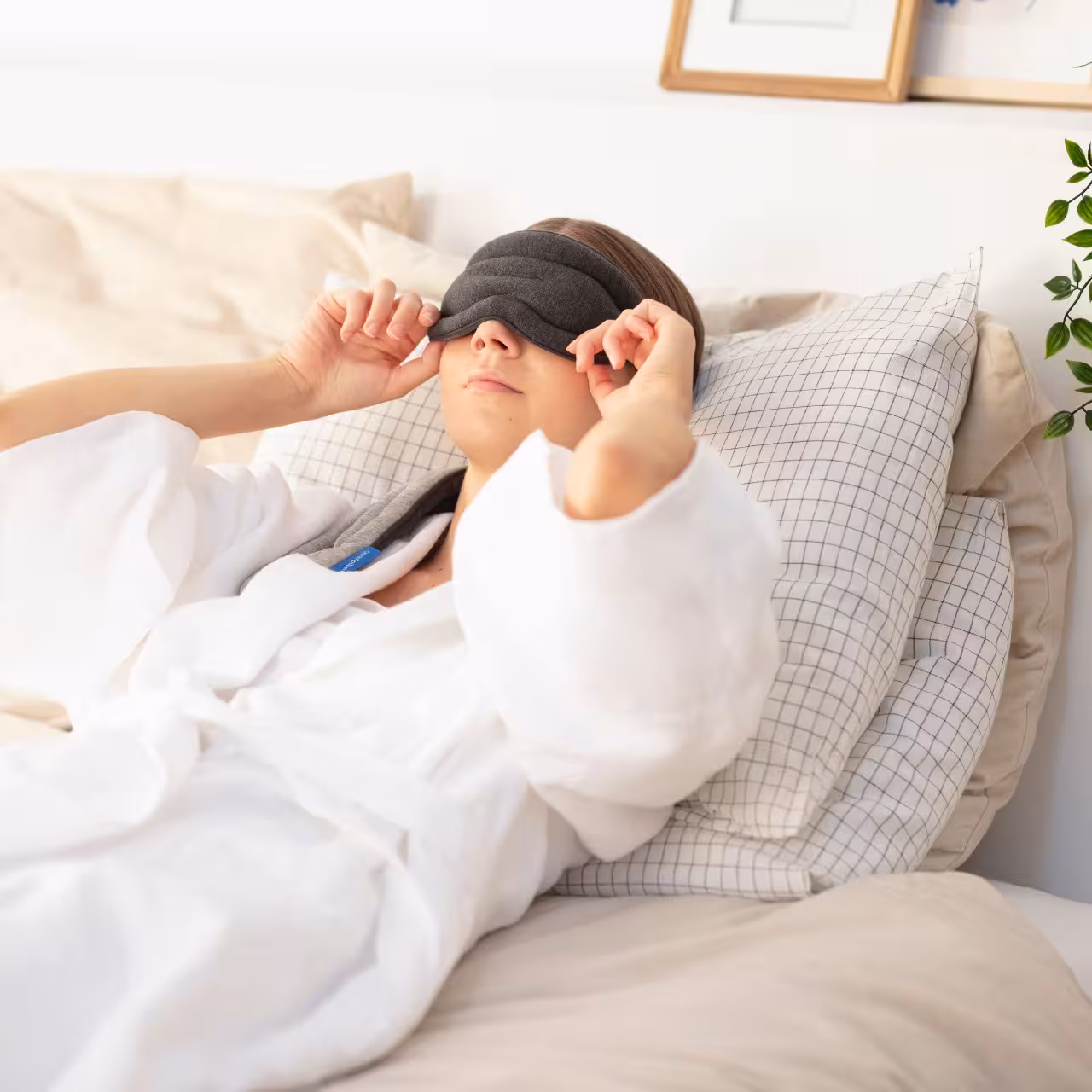 Person in Bett mit Schlafmaske