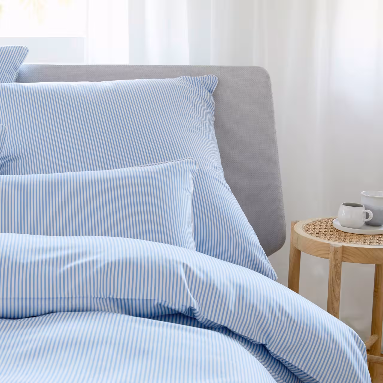 Bettwäschegarnitur blau weiß gestreift auf Bett dekoriert