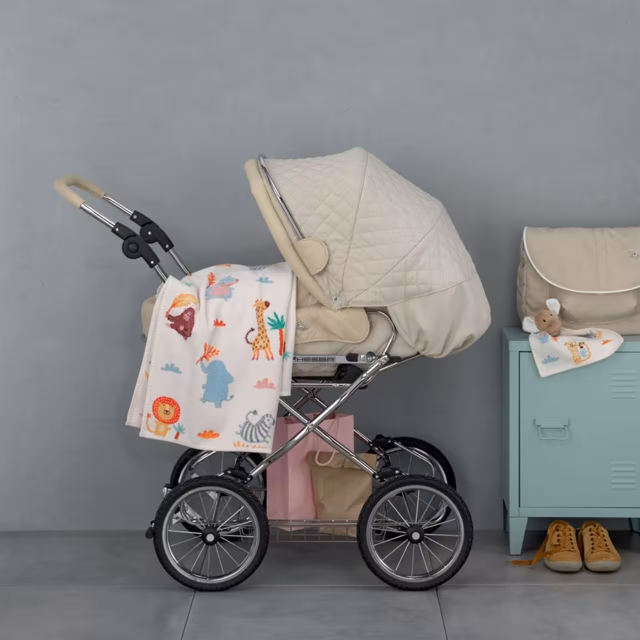 Chenilleserie Wild Safari creme mit bunten Tiermotiven  dekoriert an Kinderwagen