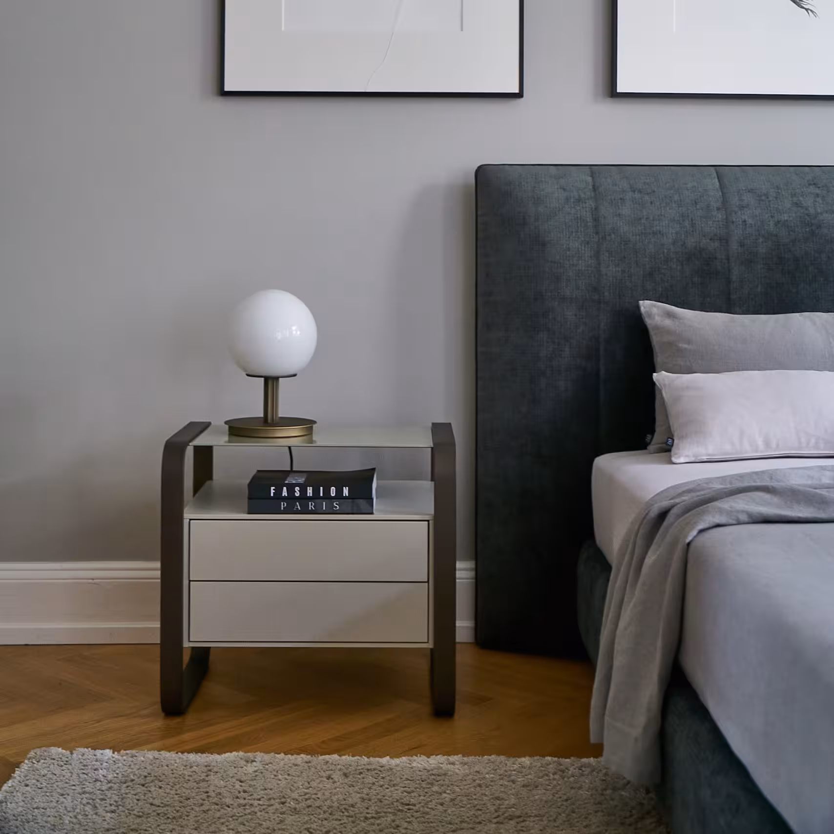 Nachttisch mit kugelförmiger Lampe neben Bett