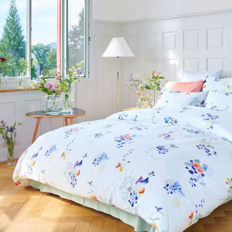 Bettwäsche von Christian Fischbacher mit Blumen in einem hellen Zimmer