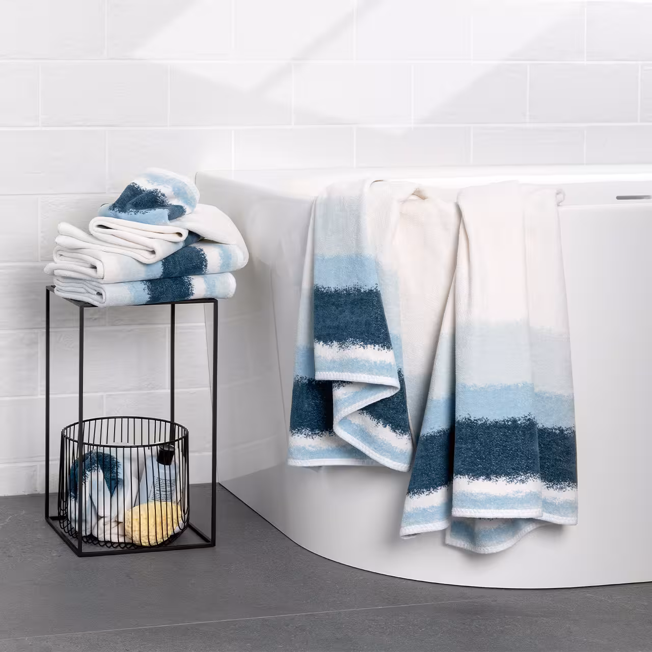 Feiler Chenille-Handtücher in Blau und Weiß an einer freistehenden Badewanne im hellen Badezimmer