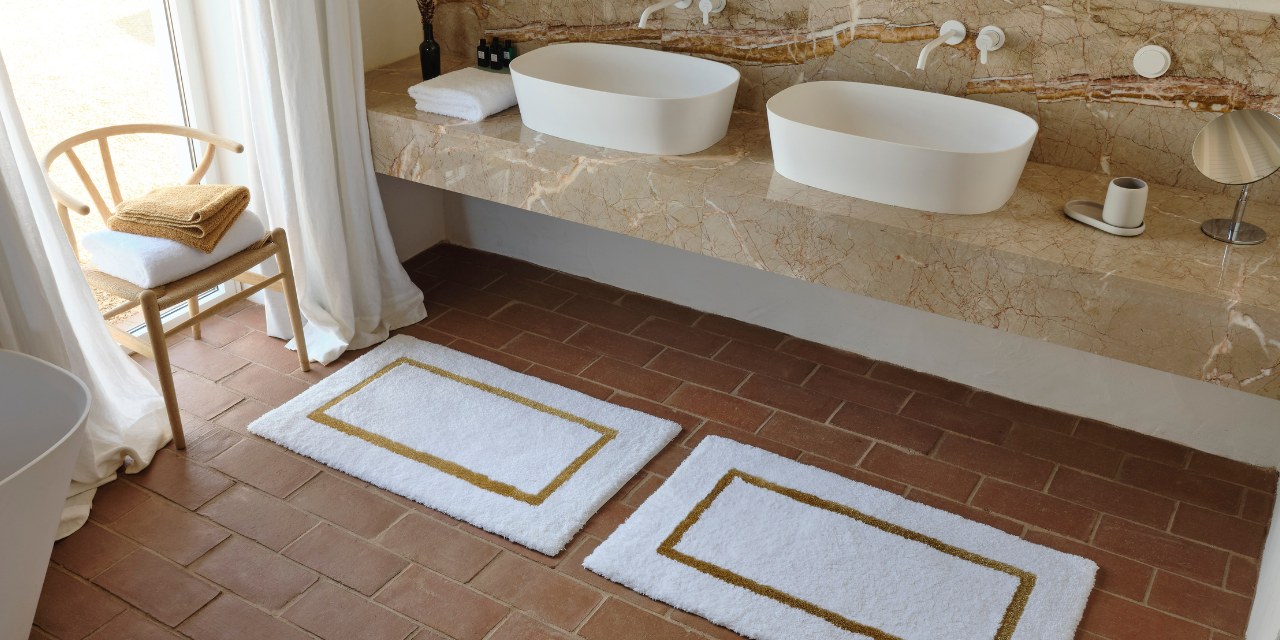 Badezimmer in Beige- und Brauntönen Badezimmer in Beige- und Brauntönen mit Marmor-Waschbecken und Abyss Handtüchern