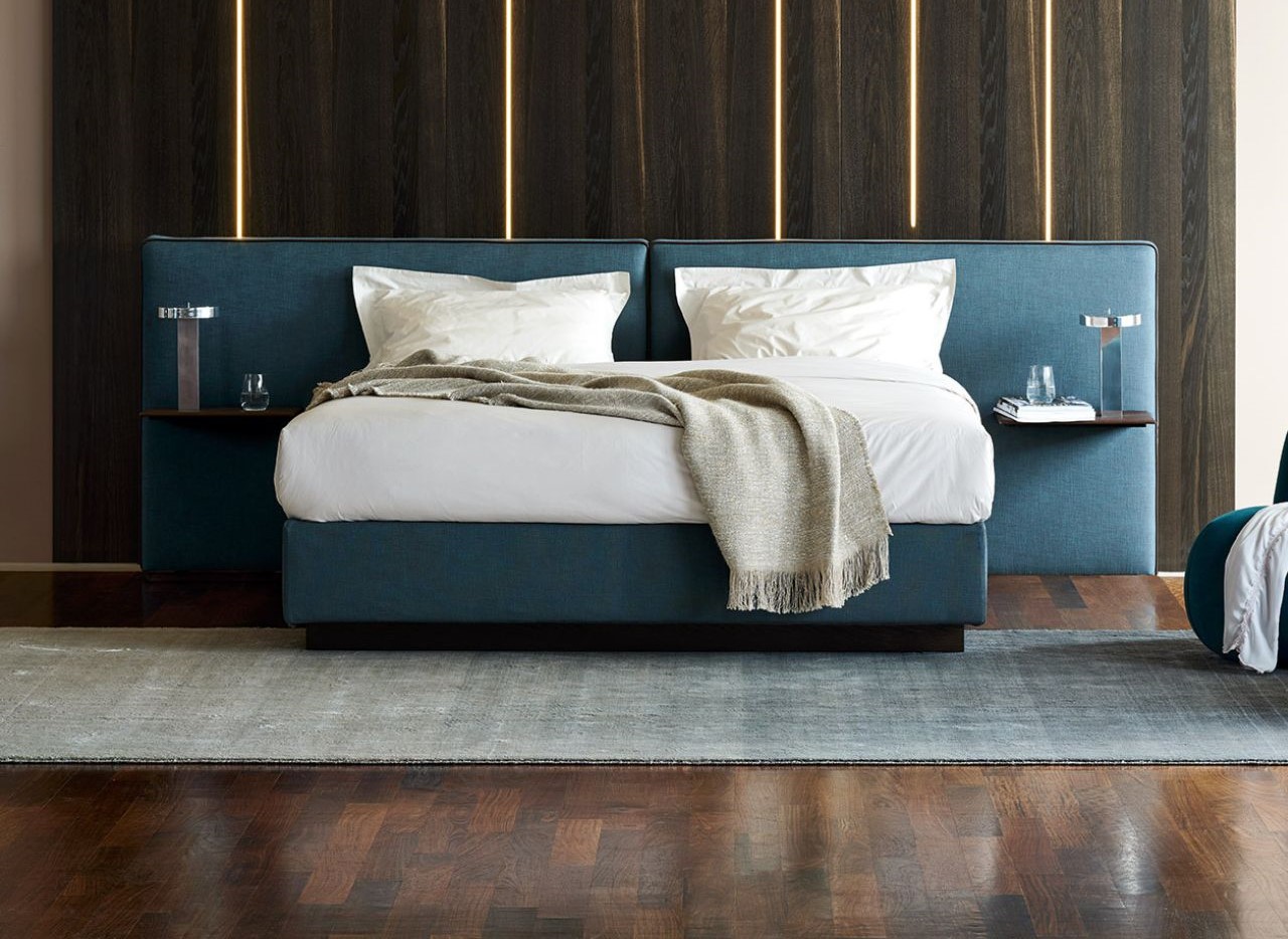 Dunkelblaue Schramm Betten auf dunklem Holzboden mit dunkler Holzwand