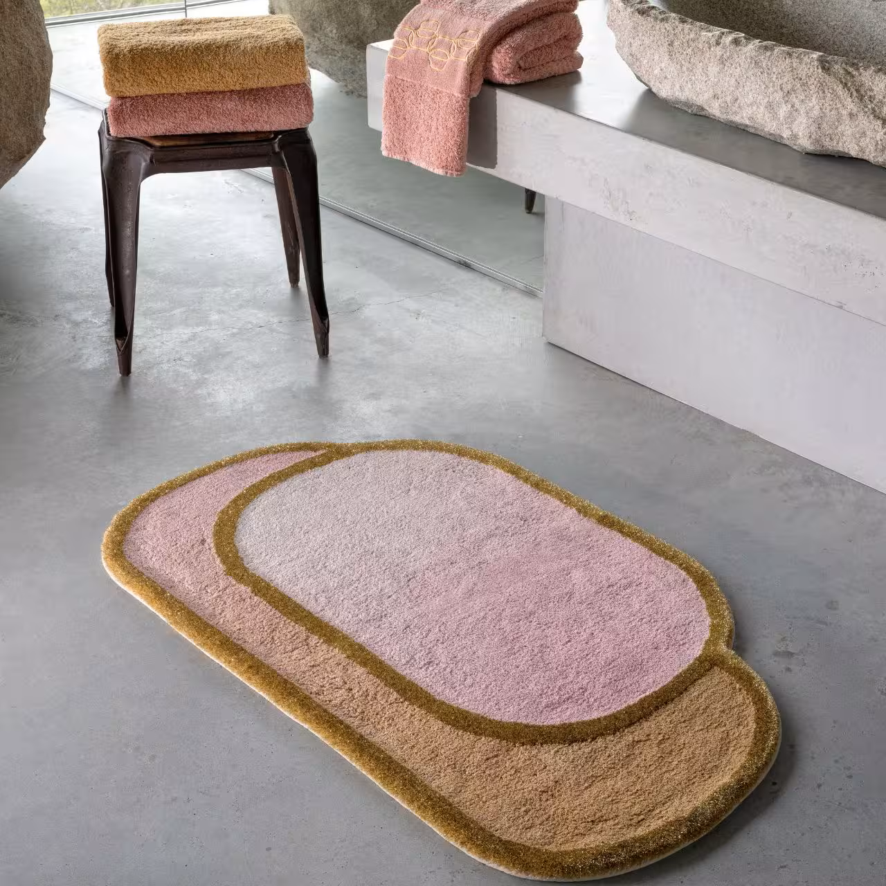 Badteppich in rosa und hellbraun neben Hocker
