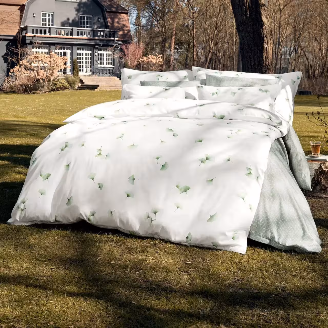Bettwäsche Aiko weiß mit Gingkoblättern auf Bett im Freien