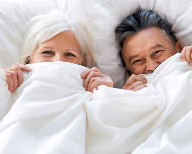 Älteres Paar unter weißer Decke