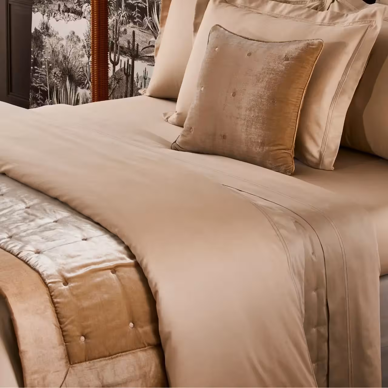 Bett mit beigefarbener Tagesdecke und Kissen