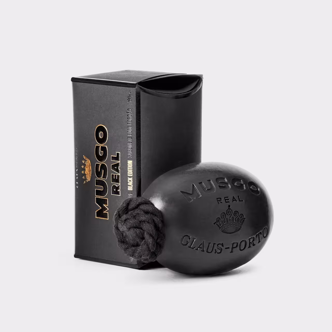 Seife Musgo Real Verpackung schwarz gold mit Seifenstück am Seil in schwarz