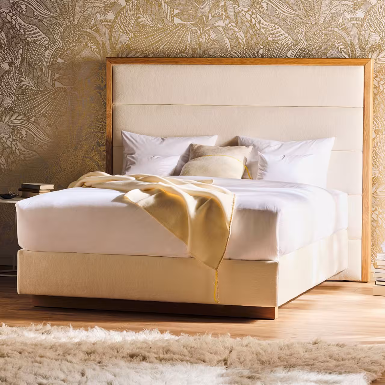Polsterbett Origins mit hellem Bezug und Holzrahmen am Betthaupt in Schlafzimmer