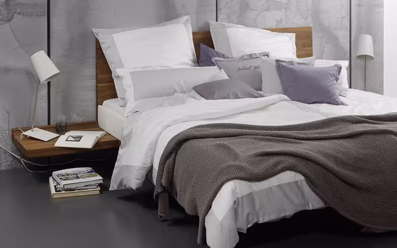 Stilvolle Bettwäsche von Graser in ruhigen Grautönen in einem grauen Zimmer